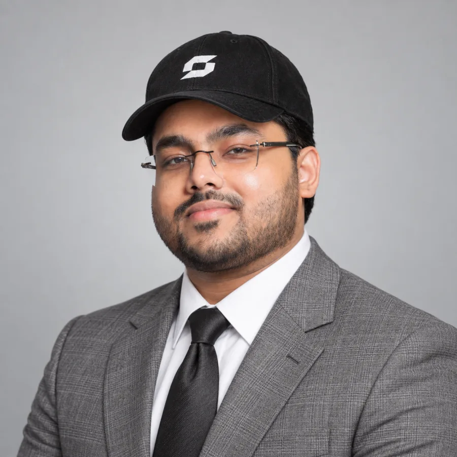 Sachin Sanjay in a grey suit and STAGE SAGA cap